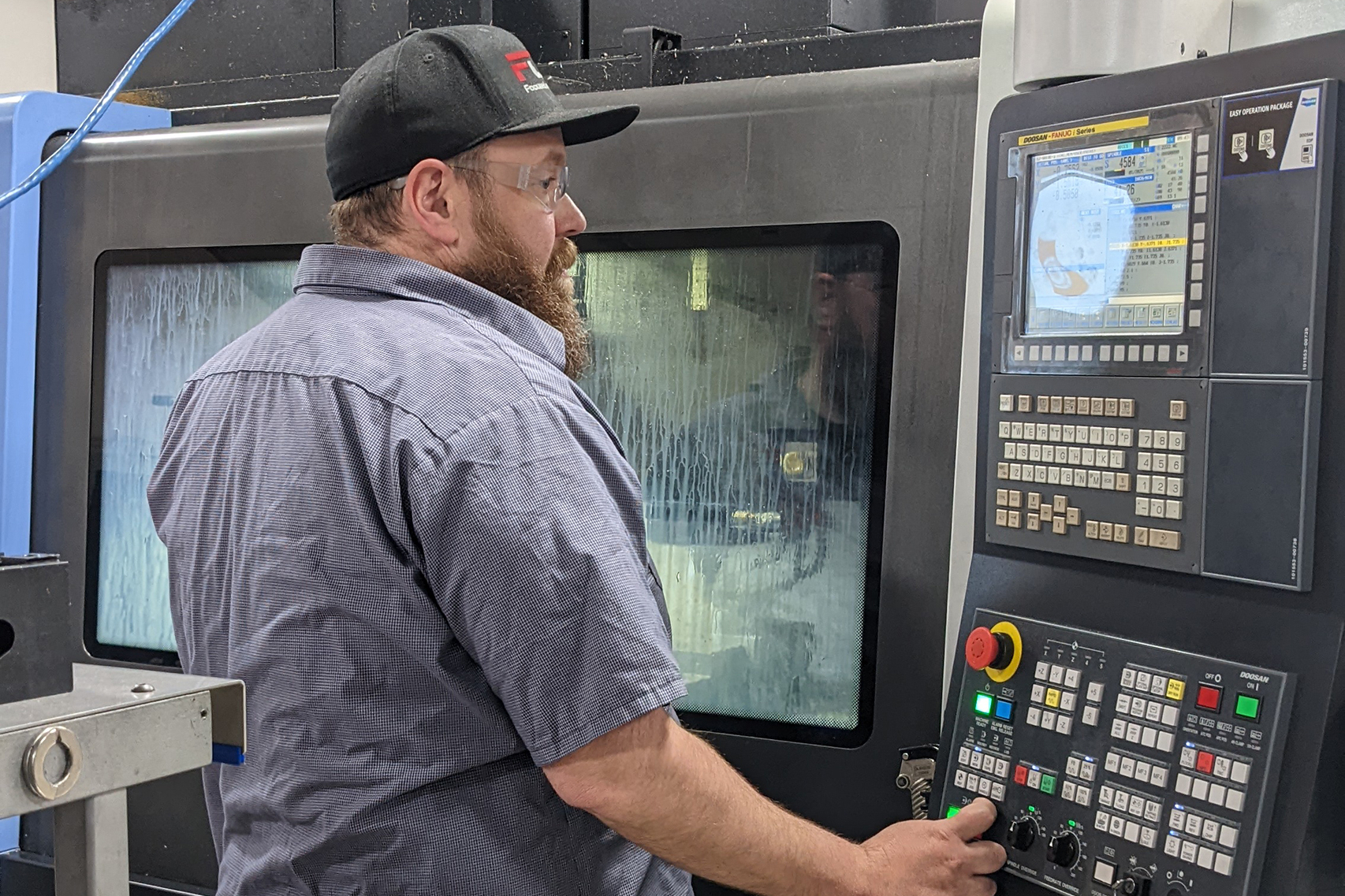 machine tool operator works at the controller for a VMC