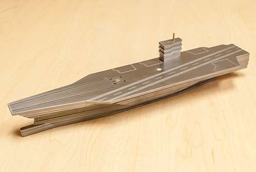 Este modelo a escala de un portaaviones, que tiene aproximadamente 280 mm de largo, muestra como un conjunto de capas cortadas rápidamente con bordes biselados o angulados produce una representación precisa de un modelo 3D de la pieza.