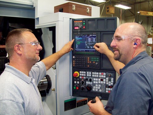 men in front of CNC control
