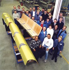 The Stork Fokker manufacturing team for the A380 leading edge poses with three finished J-nose assemblies.
