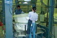 As soon as the mold begins to cool, two operators remove the cured part and prepare it for shipment.