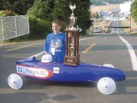 Johnny Weissgerber poses with his 3rd Place trophy and car at the top of the 2001 All-American Soap Box Derby race course.