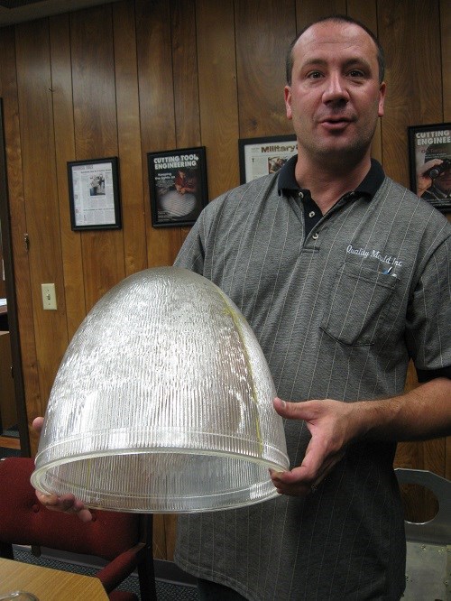 Company president, D.J. Danko, shows a piece of glass produced from an equally complex mold.