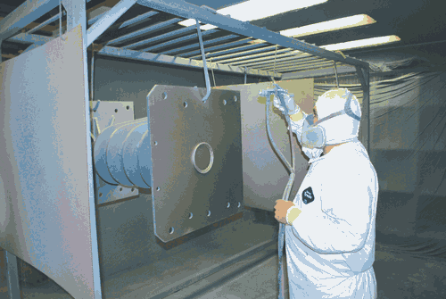 Worker applies paint and powder coatings