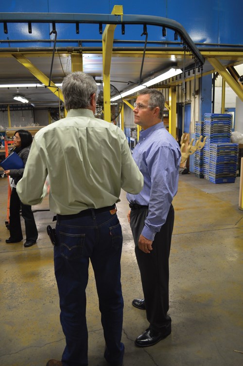Hentzen Coatings’ John Mort talks with a customer while demonstrating the new CARC powder topcoat.