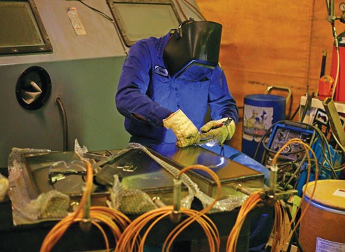 a welder works on a cleaning machine