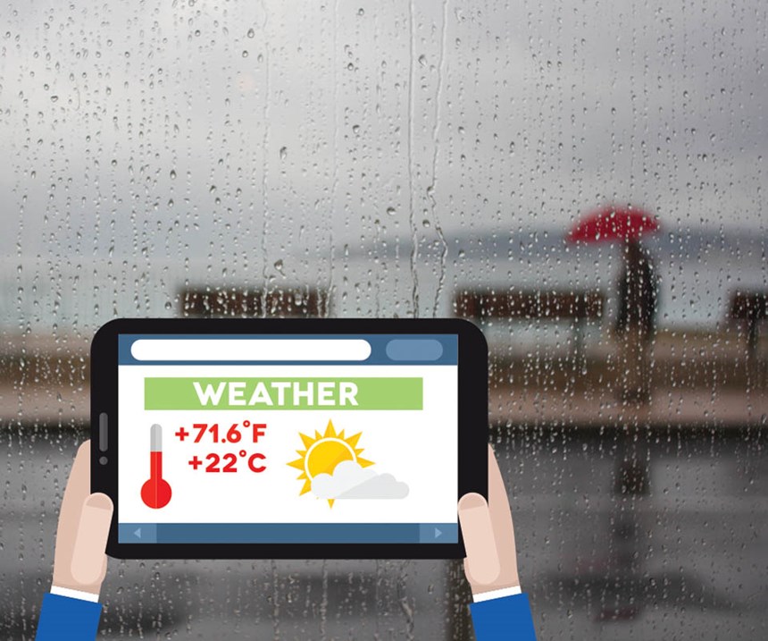 Tablet with weather displayed while looking out the window at rain.