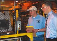 Chris Peters (right) checks on machining line with Greg Hartwig