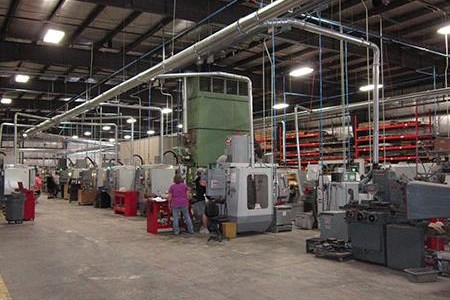 Cada una de las máquinas CNC del taller está conectada a un sistema de recolección de polvo central…