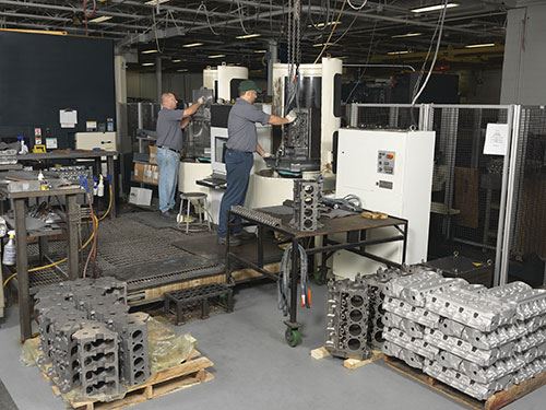 employees loading the Makino Machining Complex cell