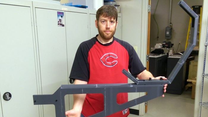 man holds 3d-printed bracket prototype