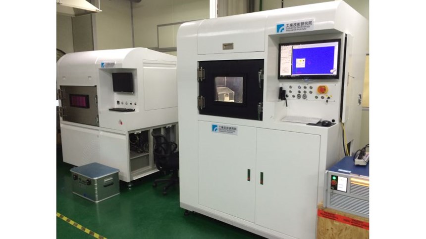 The powder-bed additive machine at right is near to commercialization. An earlier R&D model is seen at left.