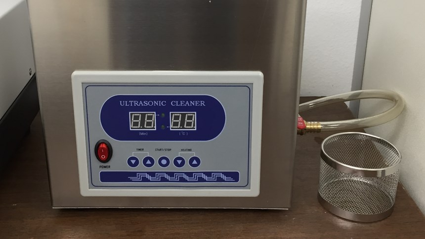 Ultrasonic cleaner used to help isolate metal powder trapped inside parts and supports