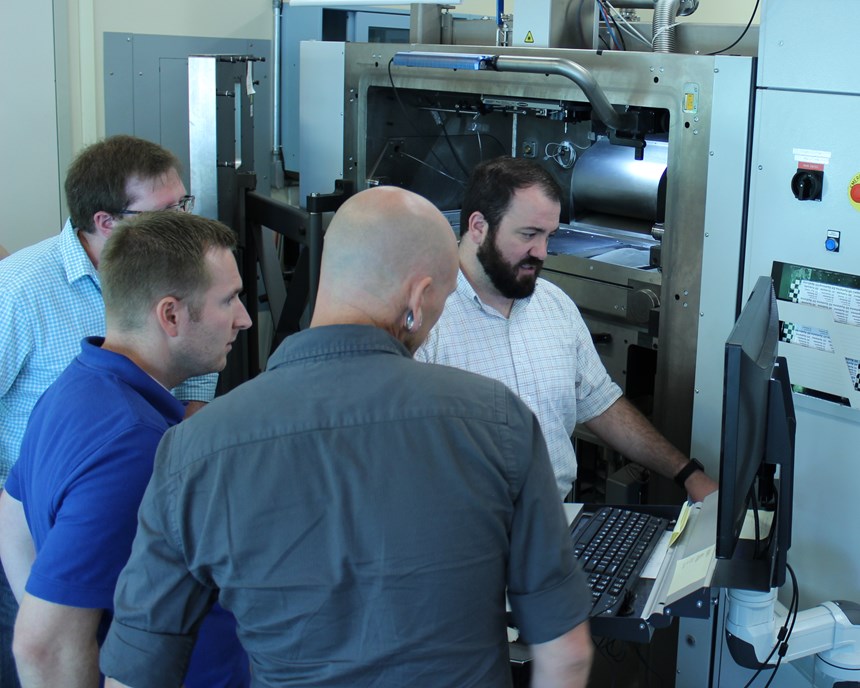 Students receiving instruction in setting up a metal AM machine