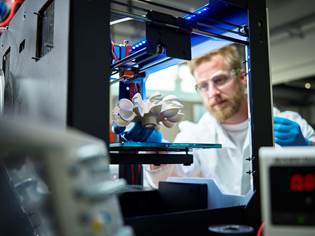 Person viewing 3D printing of a part