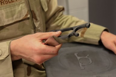 A soldier holding a freshly 3D-printed part