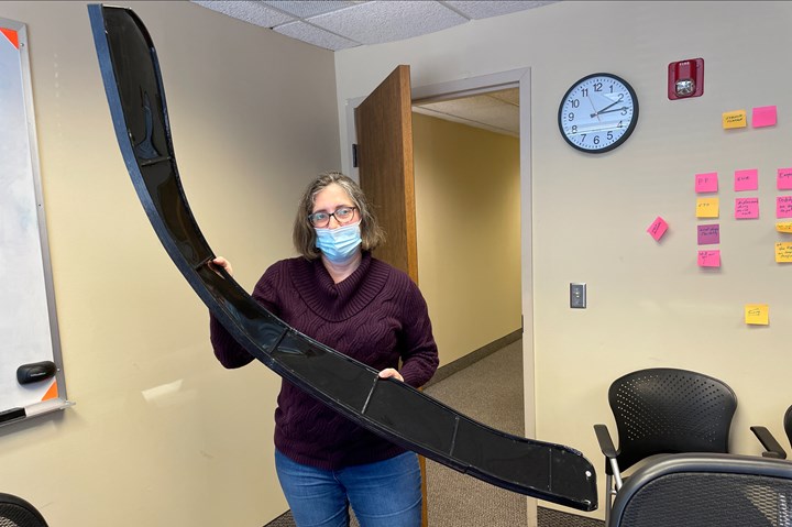 Cora Leibig holding 3D printed tractor fender 