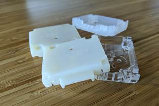 3D-printed parts in off-white, white, and clear plastic