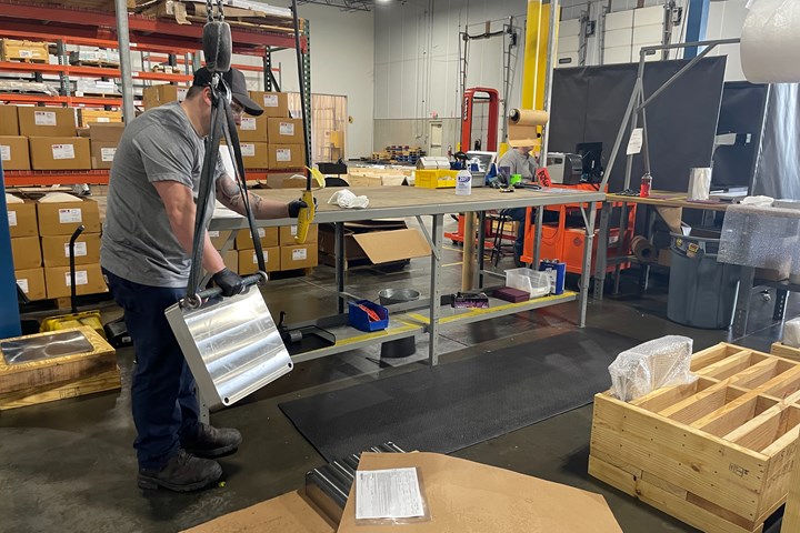 UPM employee moving a build plate to a crate 