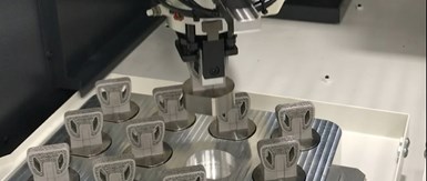robot loading AM parts with pucks