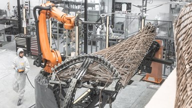 A robot precisely places fiber bundles on a winding frame.