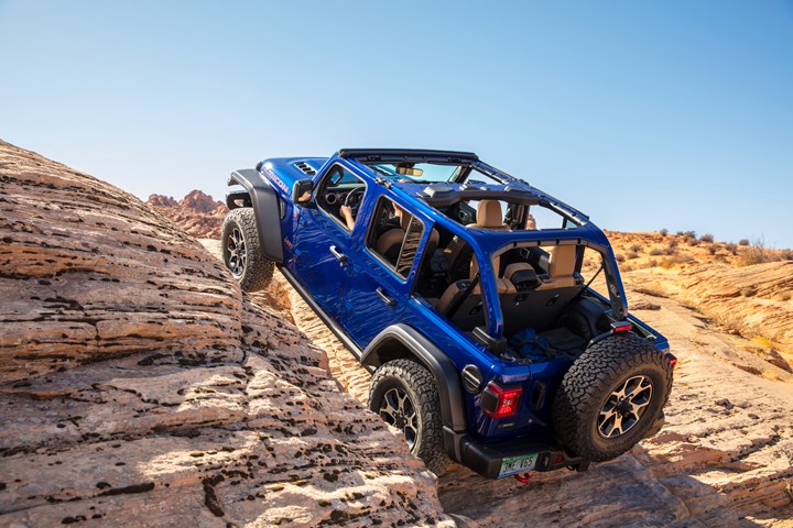 Blue 2021 Jeep Wrangler SUV climbing a steep hill.