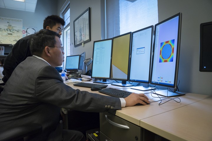 Wenbin Yu looking at simulation designs on a computer screen.