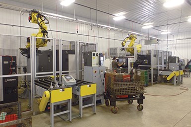 El brazo del robot está colocado por encima y detrás de los tornos Okuma para permitirles a los trabajadores utilizar de forma segura los controles de la máquina para monitorear y realizar ajustes sin entrar en el área de trabajo del robot.