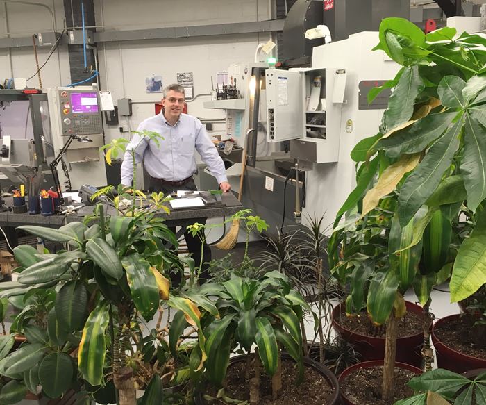 Zelinski stands among plants on shop floor at L&S Machine