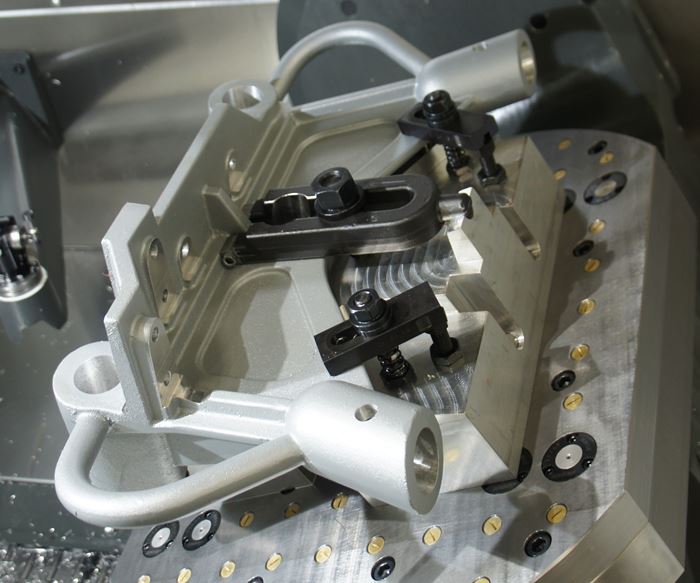 Contour Precision Milling and Machine specializes in oddly shaped, difficult-to-machine milled parts, many of which require custom fixturing. Tilting the five-axis machines’ table enables access to features like the angled bores on either end of the part.  