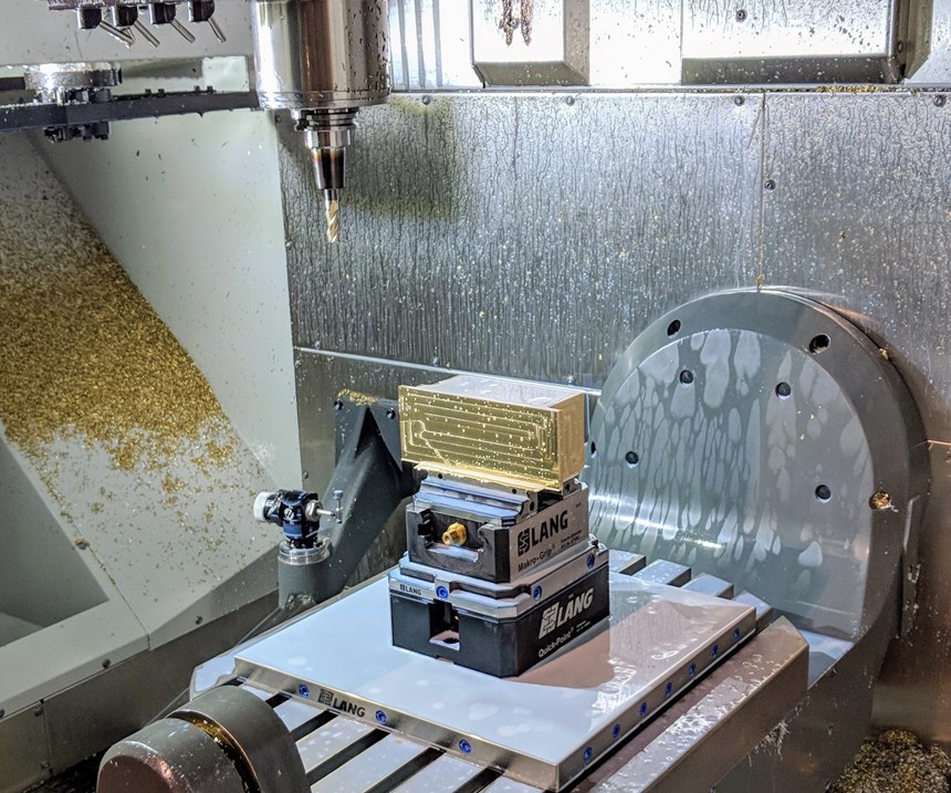 A rectangular part set up on a five-axis machining center for custom machining