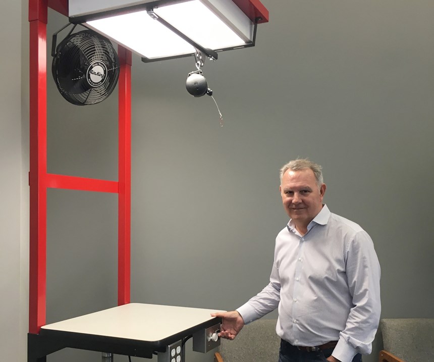 Don Dumoulin, CEO de la empresa, muestra un ejemplo de la nueva línea de estaciones de trabajo ergonómicas del taller. 