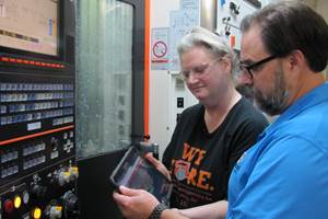 La operadora de máquina Lilly Panoff y Scott Shortess verifican un reporte de conteo de partes en la tablet de la estación de trabajo en una máquina multipropósito