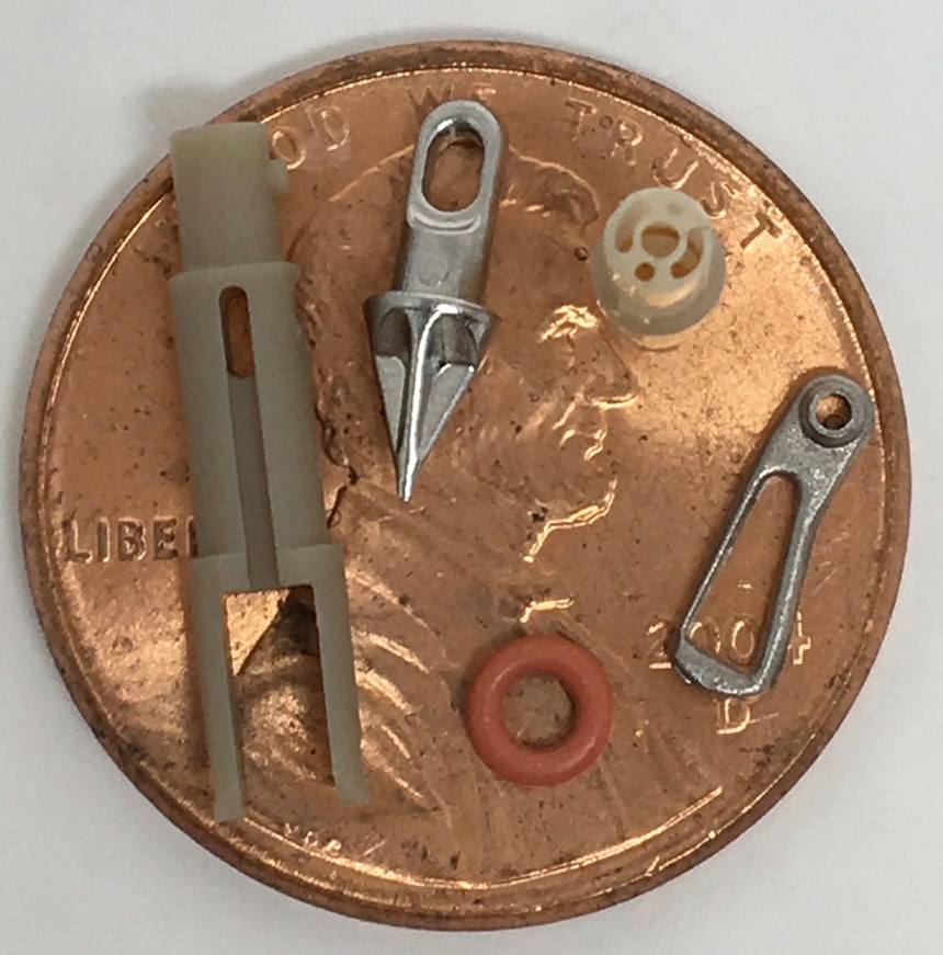 micromolded parts with penny for scale