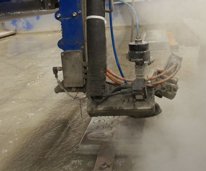 International Mold Corporation’s waterjet goes to work on a set of shims. Since installation three years ago, the machine has been employed for manifolds, ejector plates, wear plates, gibs, fixtures and various other parts. 