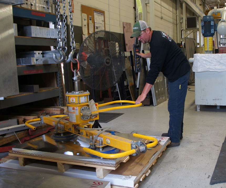 Aaron Bazydlo, primary operator of the waterjet, uses a vacuum loader to set up large plates for cutting. 