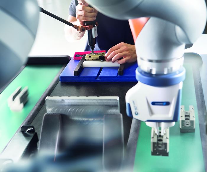 A human and a cobot with a Schunk Co-act gripper working in close proximity