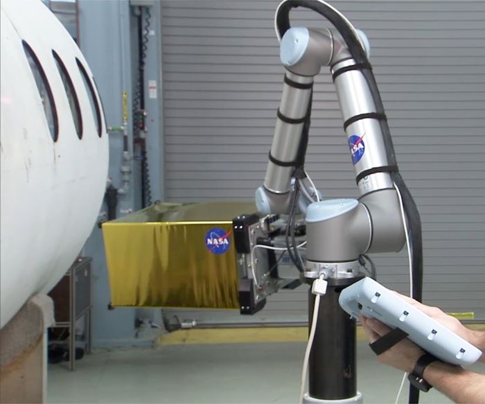 A cobot performs an infrared inspection program on an airplane fuselage