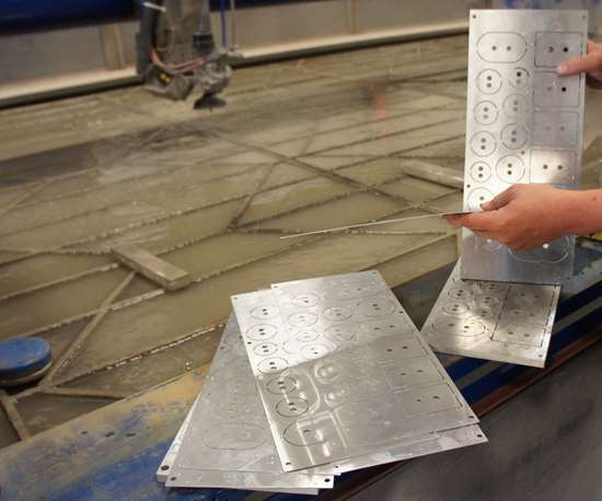 Mr. Bazydlo separates shims cut simultaneously on the waterjet. 