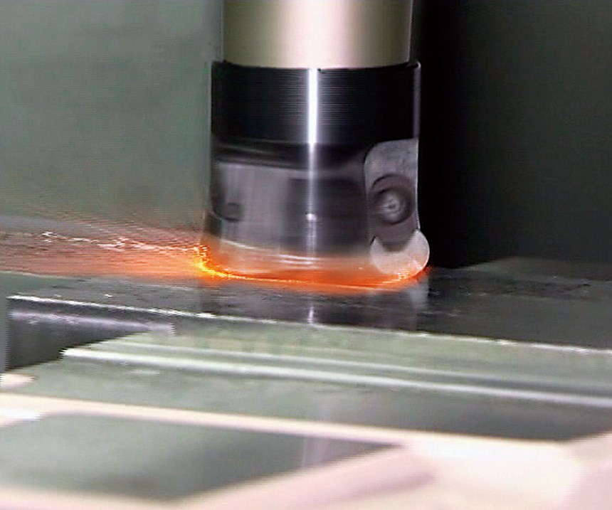 Fire spits from the workzone of a CNC machining center during a milling routine with ceramic cutting tool inserts .
