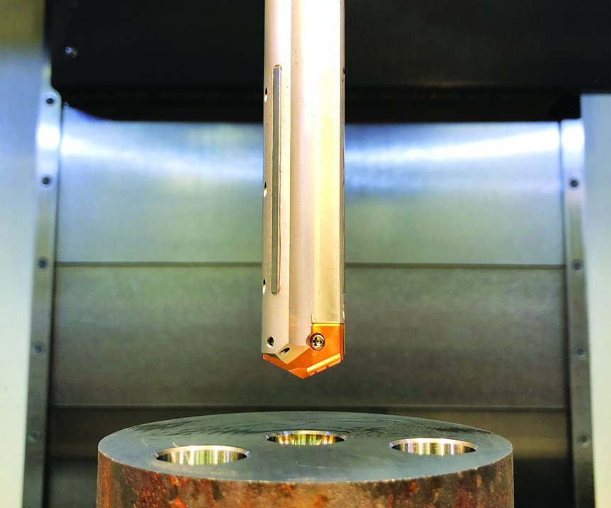 Depicted hovering over a workpiece, Allied Machine & Engineering's Stealth Drill features carbide guiding pads, extra through-coolant orifices and an adjustable locating pin that moves the insert radially to mitigate the stack-up of tolerances common to all replaceable-tip drills. 