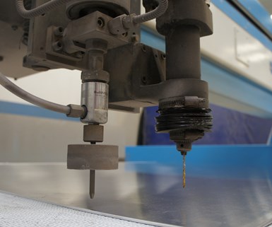 A drilling head is mounted on a large waterjet machine. 