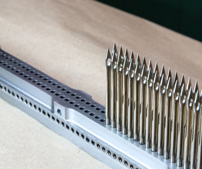 needle bar with drilled holes and tufting needles