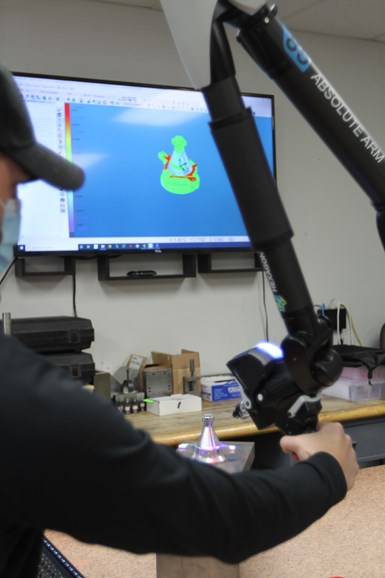 A shopfloor employee manipulates a measuring arm at Advanced Precision Engineering (APE). 