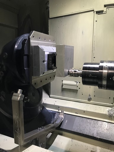Un blanco estándar en una prensa de tornillo estándar se somete a mecanizado en una de las máquinas de cinco ejes Makino A500z, de Pacon.