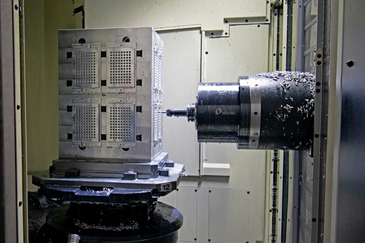A metal part undergoes CNC operations on a Makino A500Z five-axis machining center at Pacon Mfg, Inc.  