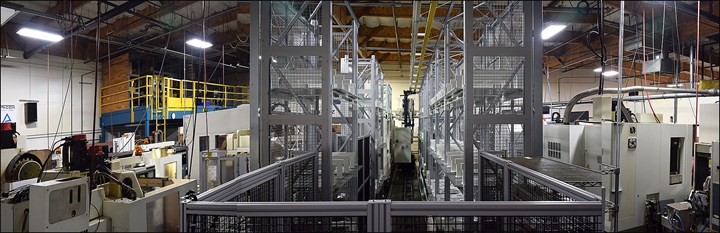 A view down a railway that transfers pallets to two five-axis CNC machining centers. 