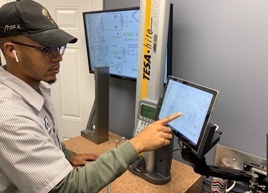 A quality control inspector enters measurement results into a computer interface at Marzilli Machine Co. 