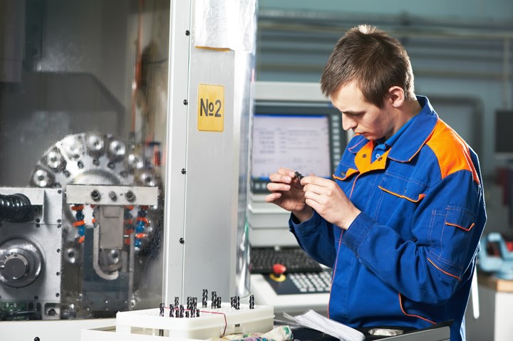 CNC operator inspecting part