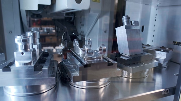 A robot arm transfers a pallet with a blank workpiece for machining at Prosper-Tech Machine & Tool.